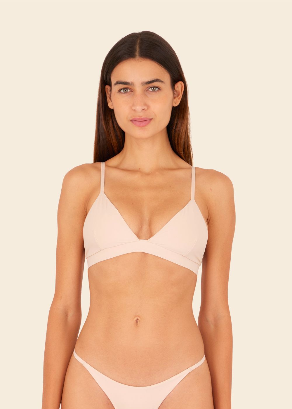 Mujer usando ropa interior en fondo entero en color beige