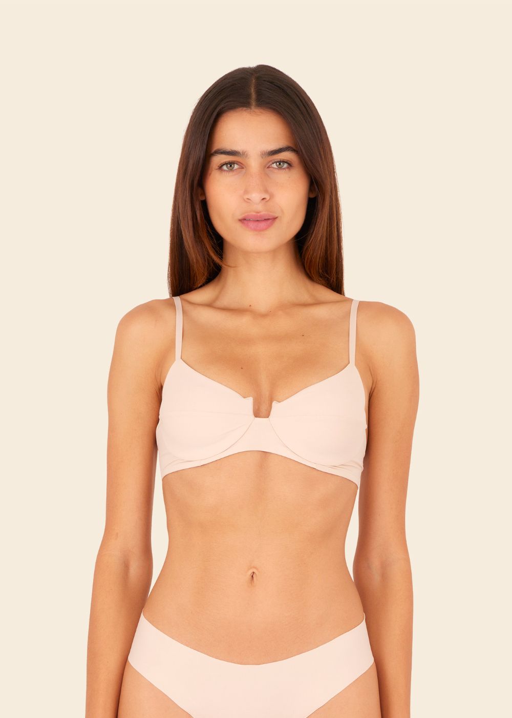 Mujer usando ropa interior en fondo entero en color beige