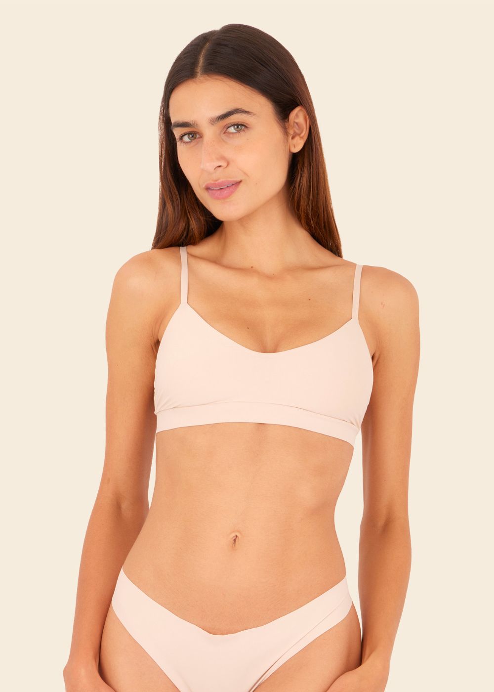 Mujer usando ropa interior en fondo entero en color beige