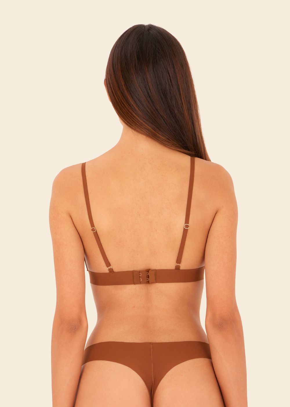 mujer de espalda en fondo blanco con un top en color terracota