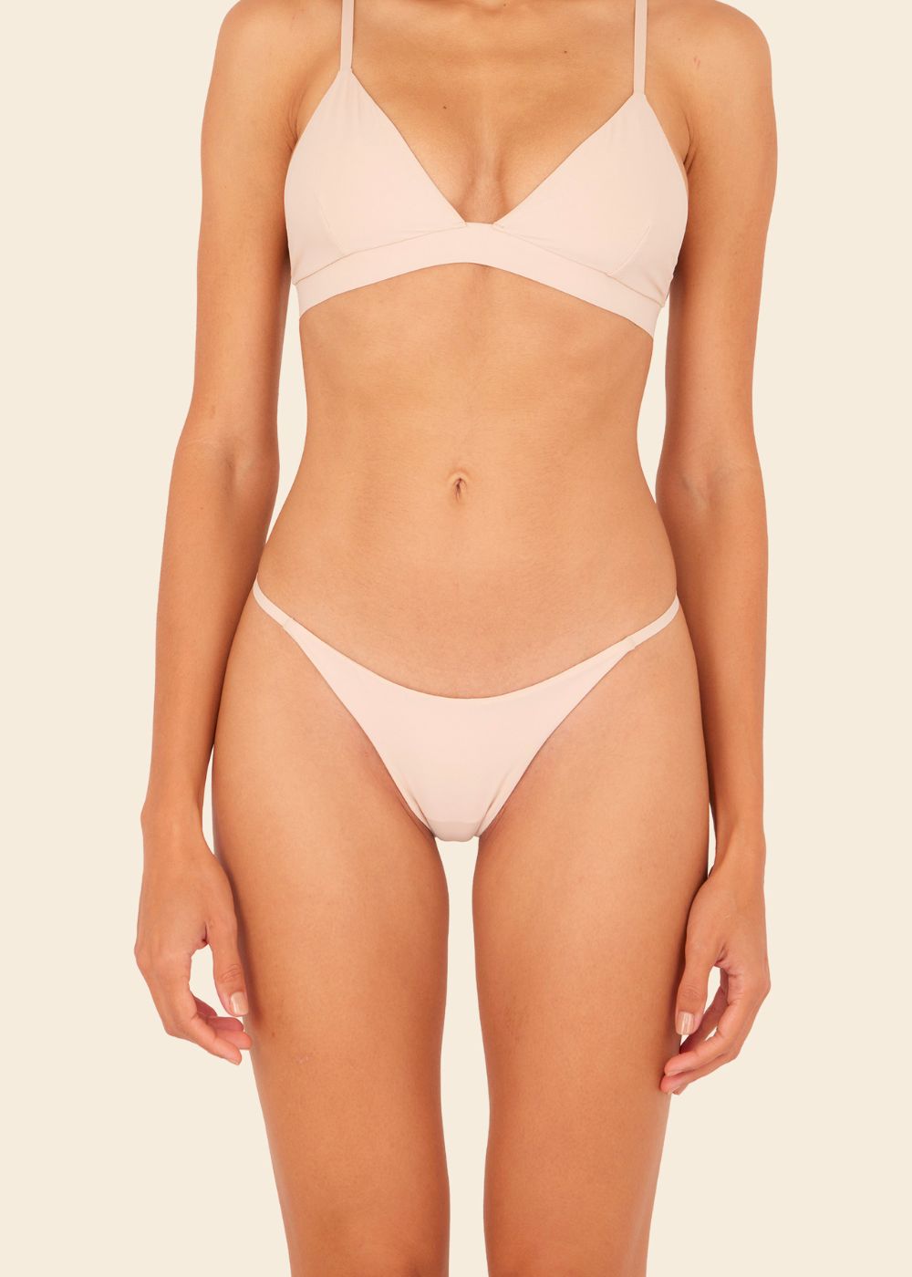 Mujer usando ropa interior en fondo entero en color beige