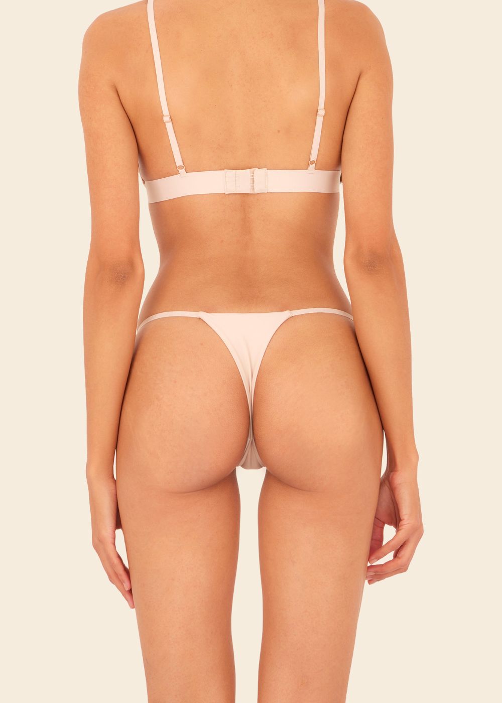 Mujer usando ropa interior en fondo entero en color beige