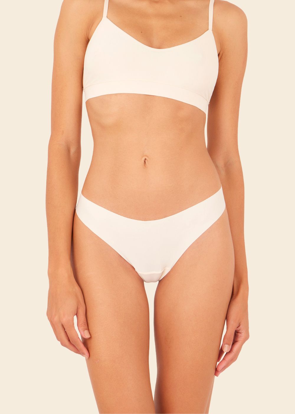 mujer en fondo blanco usando un sosten y tanga beige