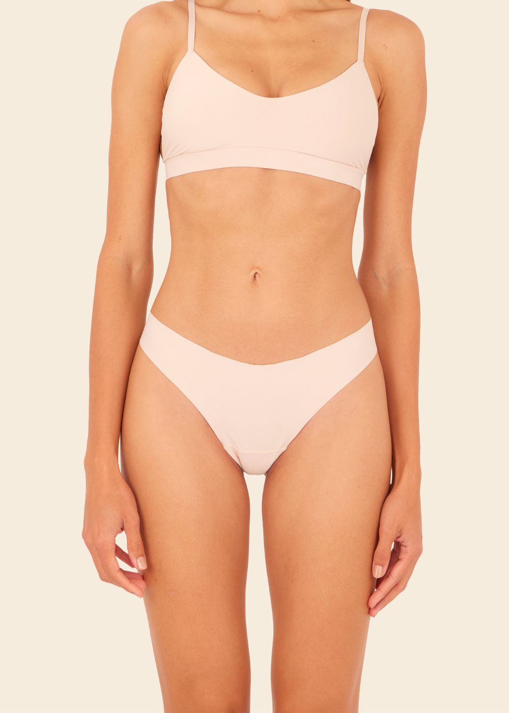 Mujer usando ropa interior en fondo entero en color beige